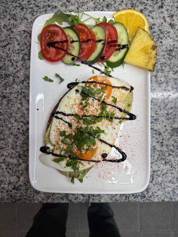 Taschte Brot mit Avocadocreme und Spiegeleiern, dazu Salat und Obst